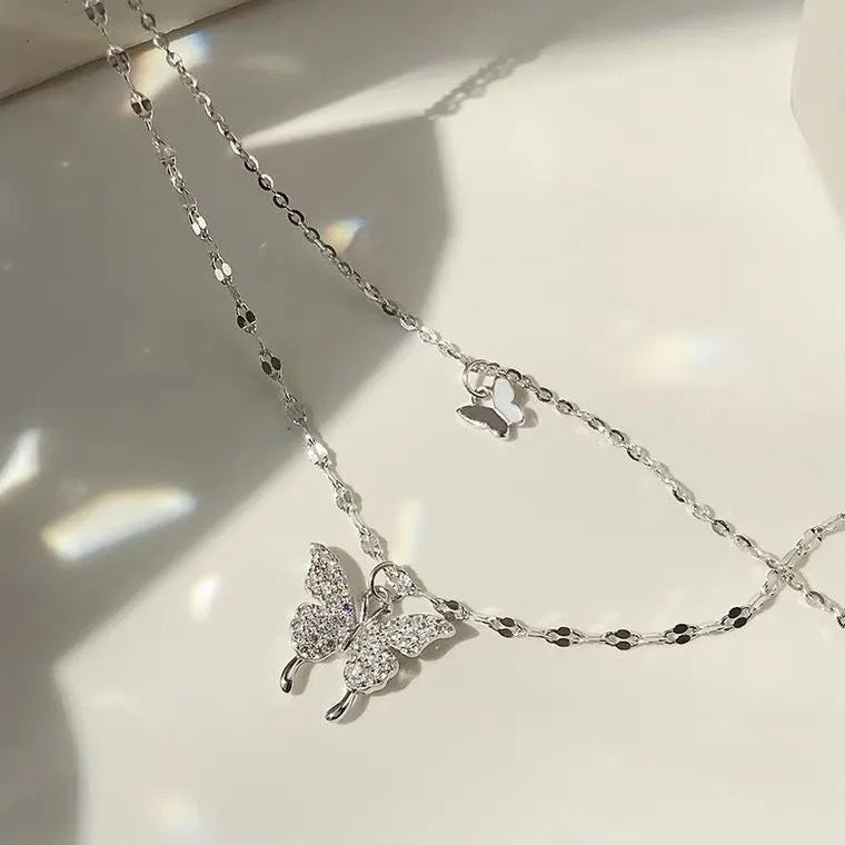 Layered butterfly pendant necklace with delicate chain detail